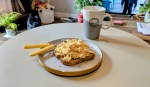 Soft scrambled eggs after being cooked in a microwave on toast. All on a table