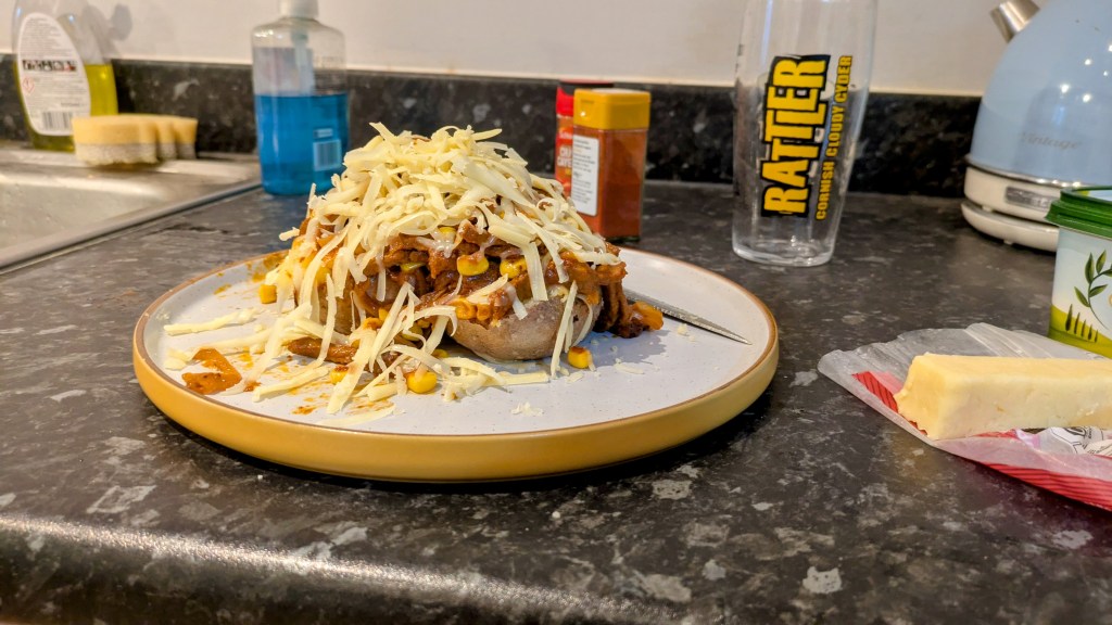A jacket potato topped with cheese and stir fry fajita beef