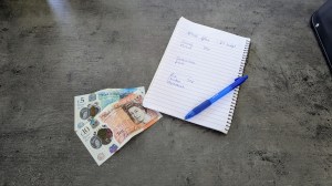 Pad and pen with a shopping list and £15 next to it