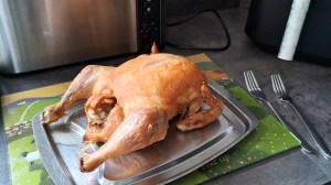 A cooked whole chicken on a worktop