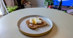 A micorwaved poached egg on a piece of toast with the yolk broken