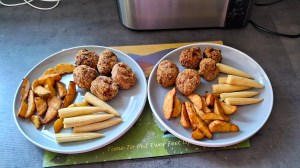 2 plates of breaded sausage balls with wedges and baby corn