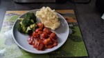 Sausage goulash, creamy mash potato and broccoli served up on a grey plate
