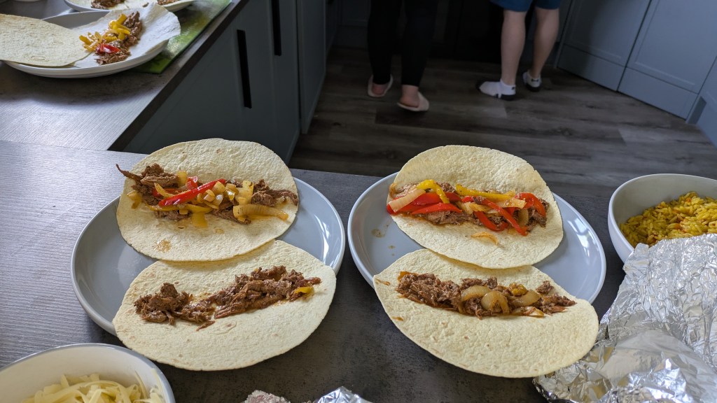 Slow cooked beef fajita, served up on 2 tortilla on a grey plate